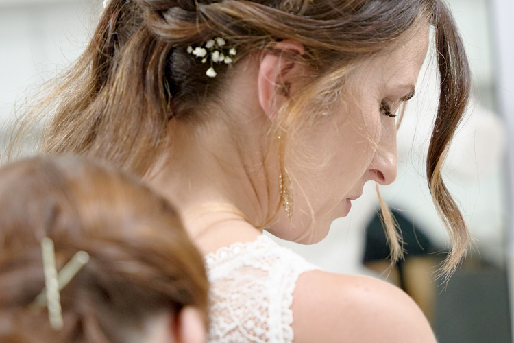 Braut blickt entspannt nach unten während des Getting Ready in sanftem Licht. Eure authentische Hochzeitsfotografie in Speyer und Stuttgart – Ja Momente.